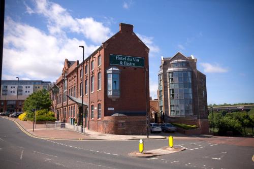 a tall brick building with a clock on it's side at Hotel Du Vin Newcastle in Newcastle upon Tyne