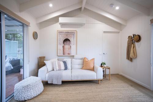 a living room with a white couch and a window at Lakeview Retreat Metung in Metung