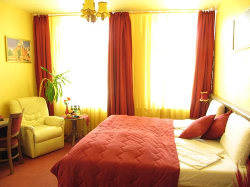 a bedroom with a bed and a chair and a window at Hotel am Hauptbahnhof in Schwerin