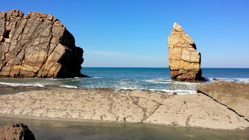 two large rocks in the ocean near the beach at Hostal la Picota in Liencres