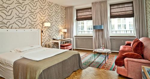 ein Hotelzimmer mit einem Bett und einem Stuhl in der Unterkunft CORTIINA Hotel in München