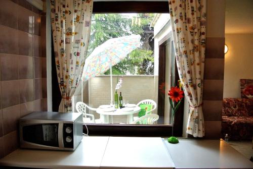 a kitchen with a microwave and a table with an umbrella at Apartment Novigrad in Novigrad Istria
