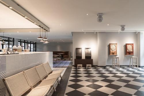 a restaurant with a checkered floor and a bar at The Moment Hotel Yilan by Lakeshore in Wujie