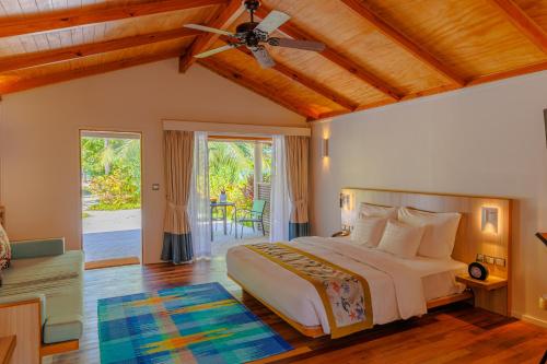 a bedroom with a bed and a ceiling fan at Meeru Maldives Resort Island in Dhiffushi
