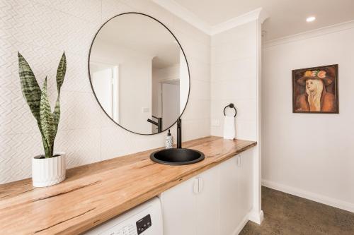 un baño con lavabo y espejo en Alley Cats, en Margaret River Town