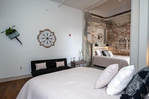 a bedroom with two beds and a brick wall at French Quarter Q in New Orleans
