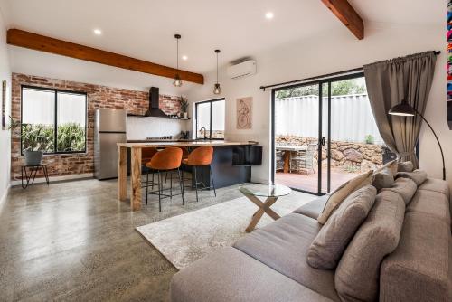 a living room with a couch and a kitchen at Alley Cats in Margaret River Town