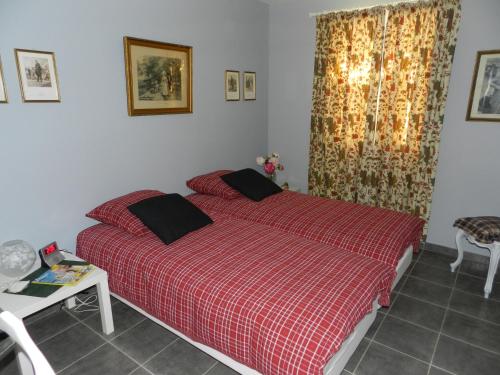 a bedroom with a bed with a red comforter at Les Broussous in Sauve