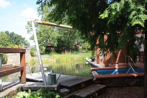 a pool with a wooden deck next to a body of water at Romantik Landhaus in Dresden
