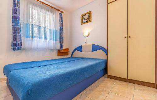 Un pequeño dormitorio con una cama azul y una ventana en 1 Bedroom Amazing Apartment In Krnica, en Krnica