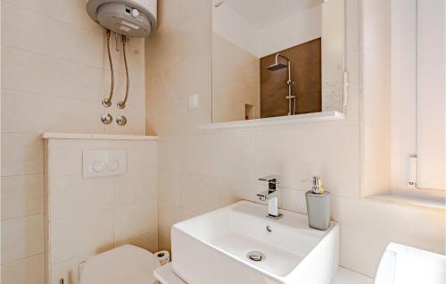 a bathroom with a sink and a toilet and a mirror at Beautiful Apartment In Prigradica With Wifi in Prigradica