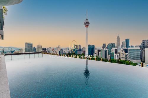 a swimming pool with a city skyline in the background at Ceylonz Suites nr Pavilion & KLCC by YourSuperhost in Kuala Lumpur
