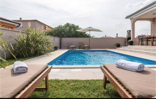 a swimming pool in a backyard with two loungers at Beautiful Home In Pula in Pula