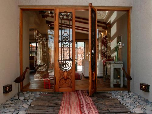a large wooden door in a room with a rug at Kkala Boutique Hotel in Salta