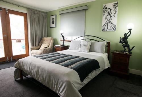a bedroom with a large bed and a chair at Kinsellas Water Views in Albany