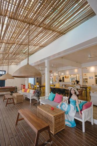 a woman sitting on a couch in a living room at Pajamas Koh Chang in Ko Chang