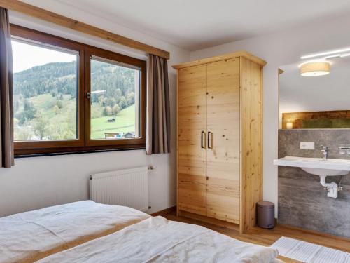 a bedroom with a bed and a sink and a window at Chalet in Kleinarl near Ski Amadé Slopes in Kleinarl
