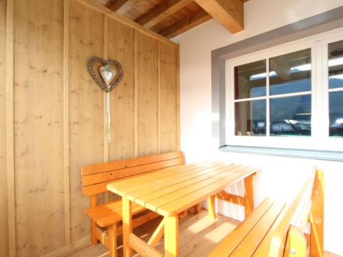 FeuringにあるApartment in Brixen im Thale near the ski areaの木製テーブルとベンチが備わるお部屋