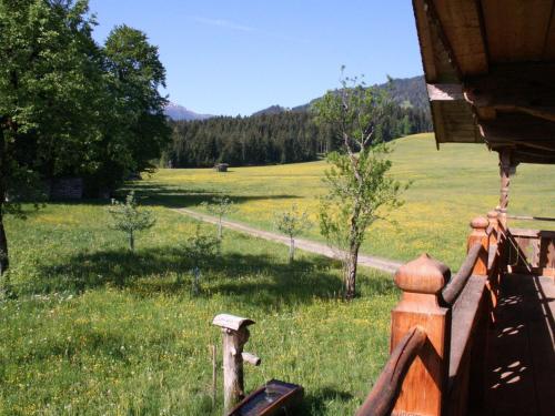 a wooden fence in a field of grass with trees at Farmhouse in Hopfgarten in Brixental with garden in Hopfgarten im Brixental