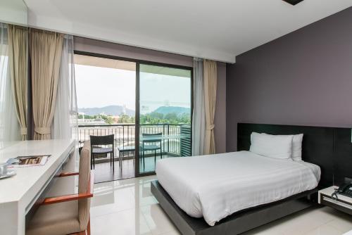 een hotelkamer met een bed en een balkon bij Suite Studio Apt With Hot Tub Bath In Front Pa Tong Beach in Patong Beach