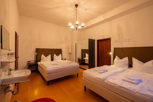 a bedroom with two beds and a sink and a mirror at Wasserschloss Podelwitz in Colditz