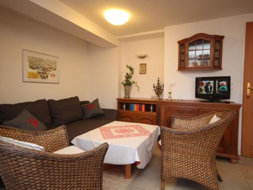 uma sala de estar com um sofá, uma mesa e cadeiras em Apartment near the Hahnenkamm cable car em Kitzbühel