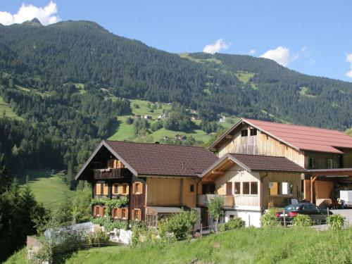 a house on a hill with mountains in the background at Apartment with view of Schruns in Schruns-Tschagguns