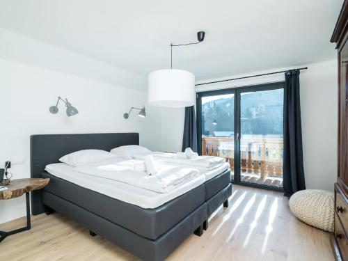 ヴァークラインにあるStylish chalet in Wagrain Salzburgerland with jacuzziのベッドルーム1室(ベッド1台、大きな窓付)