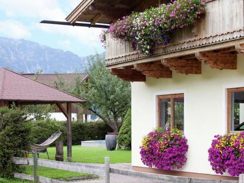 ヴァイトリングにあるCharming Apartment with Shared Pool in Waidring Tyrolの花の横の白い家