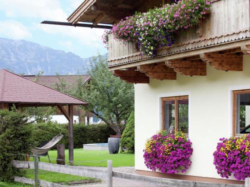 a white house with flowers on the side of it at Charming Apartment with Shared Pool in Waidring Tyrol in Waidring