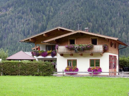 ヴァイトリングにあるCharming Apartment with Shared Pool in Waidring Tyrolの正面に花箱がある家