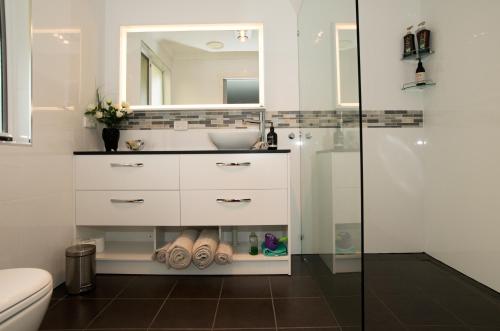 La salle de bains est pourvue d'un lavabo, de toilettes et d'un miroir. dans l'établissement Kinsellas Water Views, à Albany