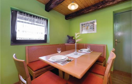 a dining room table and chairs with a wooden table and a window at Two-Bedroom Holiday Home In Ozalj in Ozalj