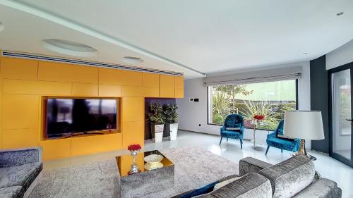 - un salon avec un canapé et une télévision dans l'établissement Villa Bonsai, à Arco da Calheta