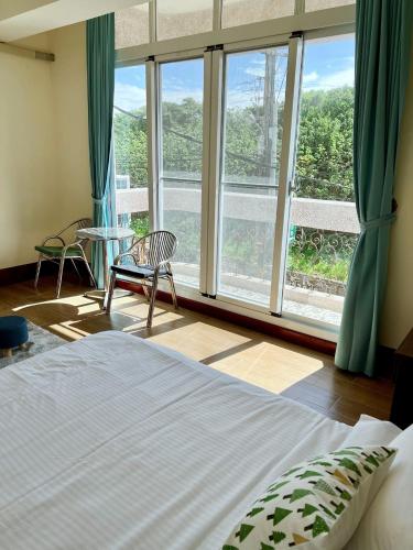 a bedroom with a bed and a large window at 墾丁 63民宿 in Kenting