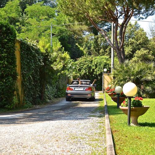 a car driving down a driveway with a man in the back at Hotel Villa Fiorisella in Marina di Massa