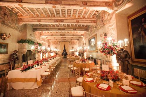 a banquet hall with tables and chairs in a building at Hotel Torre di San Martino in Gazzola Di Rivalta