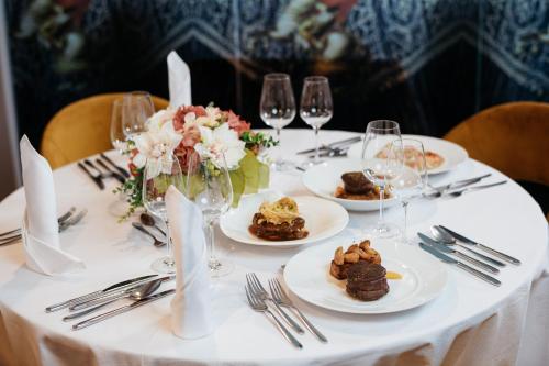 a white table with plates of food and wine glasses at Spa Suite Dobrna - Terme Dobrna in Dobrna