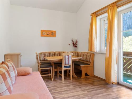 グロースアルルにあるModern Apartment in Gro arl Salzburg with Saunaのリビングルーム(テーブル、椅子、窓付)