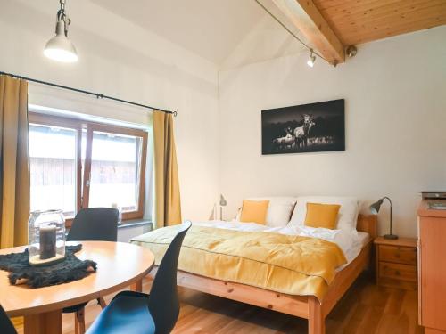1 dormitorio con 1 cama y 1 mesa con sillas en Loft like apartment in Scheibbs with swimming pond, en Scheibbs