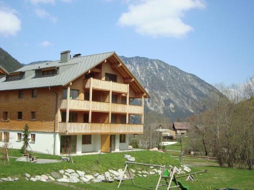 un gran edificio de madera con montañas en el fondo en Apartment at the ski lift in Brand in Vorarlberg, en Brand