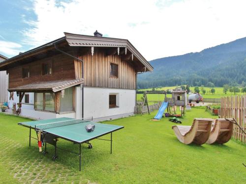 einen Hof mit einer Tischtennisplatte und einem Haus in der Unterkunft Spacious Apartment with Sauna in Leogang in Leogang