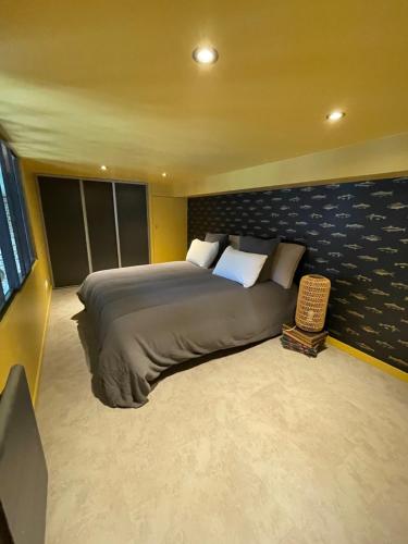 een slaapkamer met een groot bed in een kamer bij "Curiosités", place de parking privative, centre ville in Dieppe