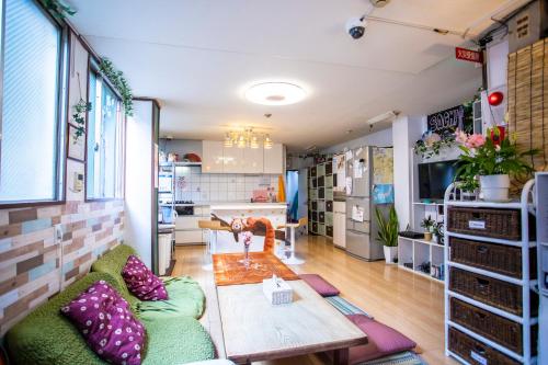 a living room with a couch and a table at Peace House Sachi in Osaka