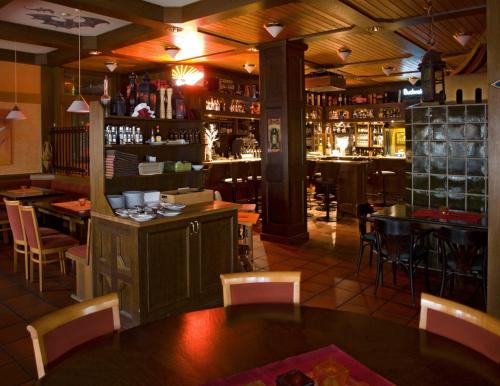 ein Restaurant mit einer Bar, einem Tisch und Stühlen in der Unterkunft Hotel Hembacher Hof in Rednitzhembach