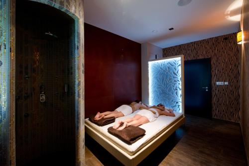 two people laying on a bed in front of a mirror at Resort Johanka in Kamenice nad Lipou
