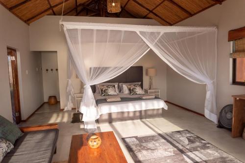 a bedroom with a bed with a canopy at Bela Flor Beach Front Apartments in Inhambane