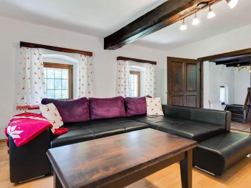 ein Wohnzimmer mit einem schwarzen Ledersofa und einem Tisch in der Unterkunft Spacious holiday home in Eberstein Carinthia with sauna in Eberstein
