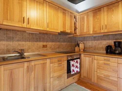 a kitchen with wooden cabinets and a sink at Holiday home in Eberstein Carinthia with sauna in Eberstein