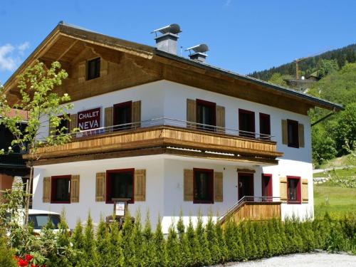 a large white building with a wooden roof at Fantastic chalet in Saalbach Hinterglemm Salzburgerland for 22 people in Saalbach Hinterglemm